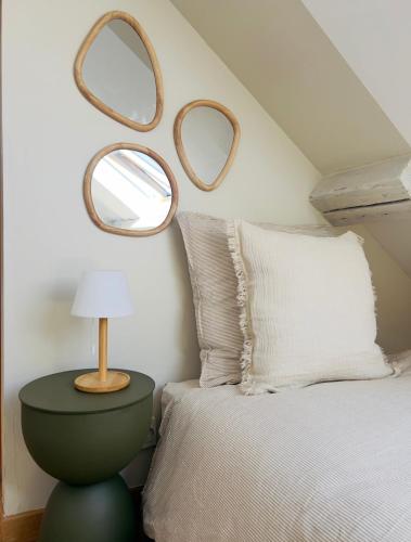 a bedroom with a bed and two mirrors on the wall at La Terrasse de L Anse Maison avec Vue Mer et Spa Extérieur in Fermanville