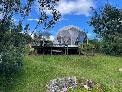 a building with a dome on top of a field at El Alpino Cabaña Glamping & Camping in Guatavita