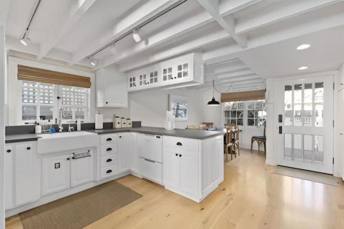 a large kitchen with white cabinets and a dining room at Riverhouse in Capitola