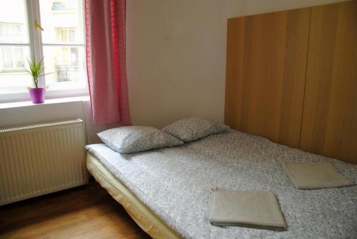 a bedroom with a bed with two pillows and a window at Central Station Hostel in Warsaw
