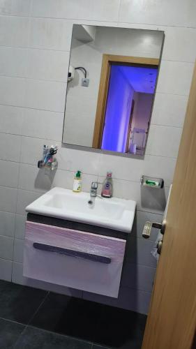 a bathroom with a white sink and a mirror at Bel appartement in Casablanca