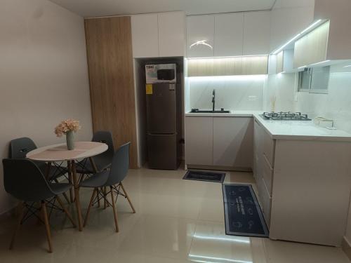 a kitchen with a small table and a refrigerator at Moderna suite en centro de Guayaquil in Guayaquil
