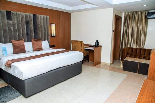 a bedroom with a bed and a desk and a chair at Villa Toscana Victoria Island Lagos in Lagos