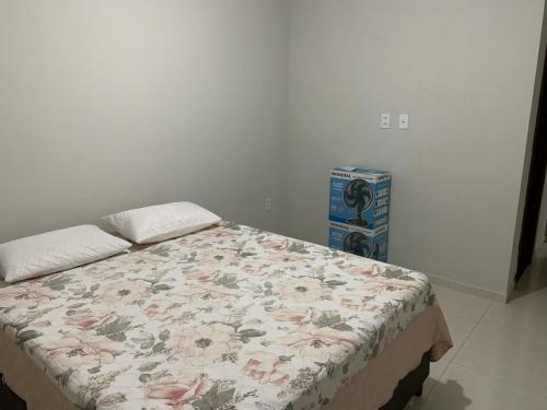 una camera da letto con un letto con un piumone floreale di Casa Temporada Prado-BA a Prado