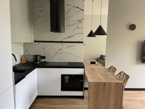 a kitchen with a counter and a wooden table at Apartamenty Arkady in Police