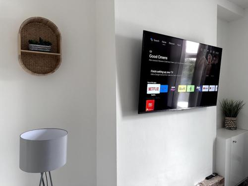 a living room with a tv on a wall at Cosy Haus in Manchester