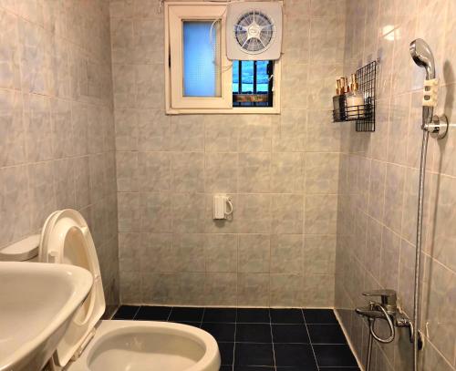 a bathroom with a toilet and a sink and a window at 블레싱하우스 in Seoul