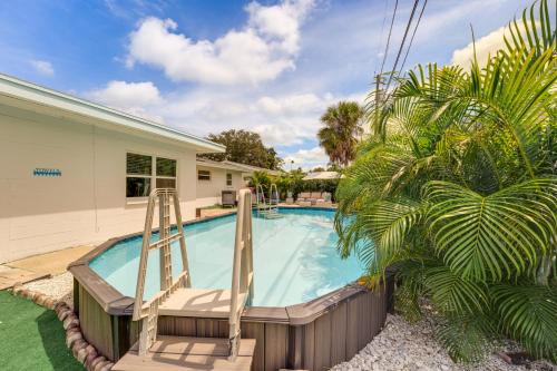 a swimming pool with a slide in front of a house at 4 Mi to Beaches Seminole Charmer with Outdoor Oasis in Seminole