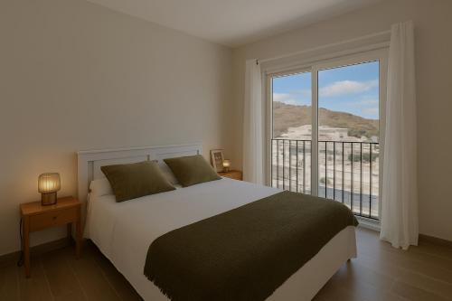 a bedroom with a bed and a large window at Villa RIHIVELI in Mogán