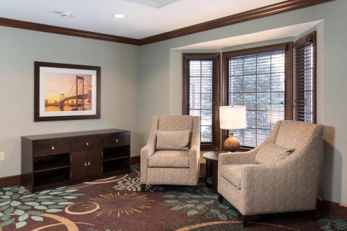 a living room with two chairs and a table at Staybridge Suites Toledo/Maumee by IHG in Maumee