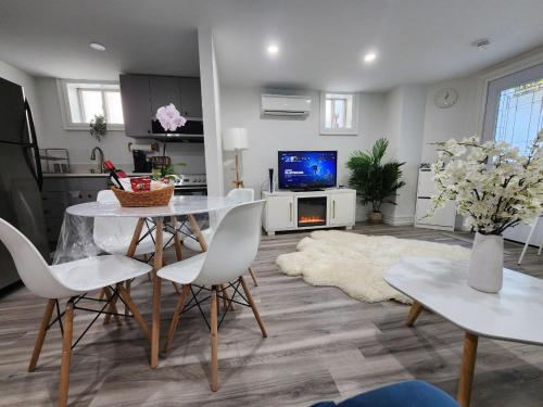 a living room with a table and chairs and a tv at Entire 2BR Apt in Midtown Toronto, walk to Subway & Shops in Toronto