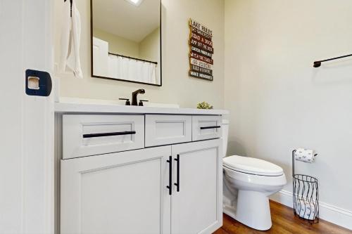 a bathroom with a white sink and a toilet at Sunset Reflection Chalet in La Follette