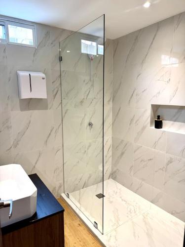 a bathroom with a shower with a glass door at Quinta Piedad Suites in Guayaquil