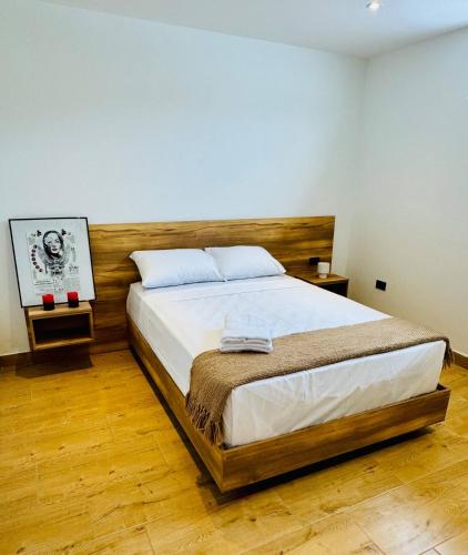a bedroom with a large bed with a wooden headboard at Quinta Piedad Suites in Guayaquil