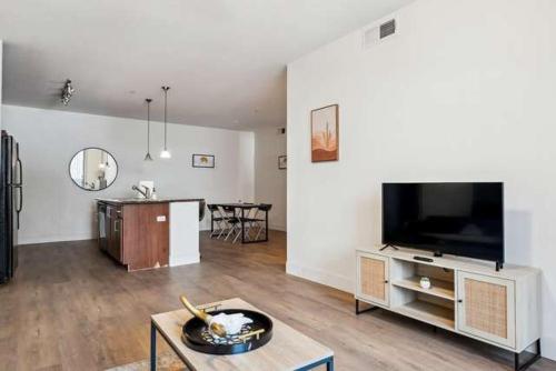Shamrock Mobile Home ParkにあるCozySuites Glendale - Westgate with pool 17のリビングルーム(薄型テレビ、テーブル付)