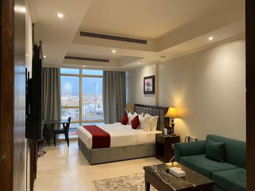 فندق اكارم الصفا Akarem Hotel في جدة: غرفة فندق بها سرير وأريكة