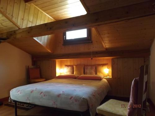 a bedroom with a large bed in a wooden ceiling at B&B Sòl Fiorì in Agordo