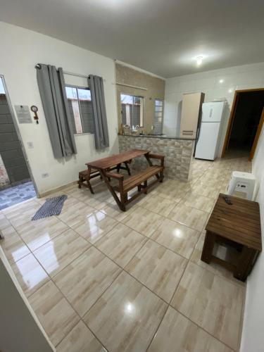 Il comprend un salon avec une table en bois et une cuisine. dans l'établissement AmaralHouse, à Itanhaém