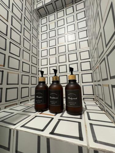 three bottles of soap sitting on a table in a bathroom at Departamento 1BD con AC y terraza en el centro de Barranco in Lima