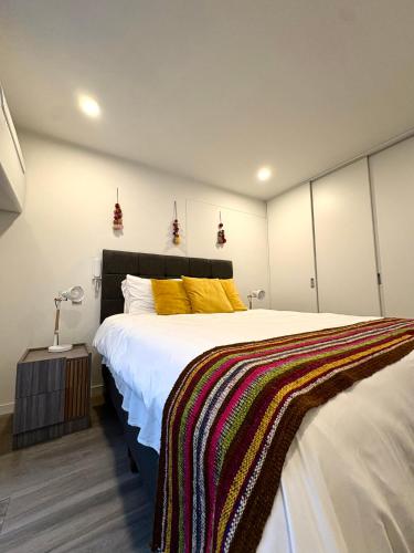 a bedroom with a large bed with yellow pillows at Departamento 1BD con AC y terraza en el centro de Barranco in Lima