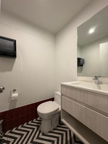 a bathroom with a toilet and a sink at Departamento 1BD con AC y terraza en el centro de Barranco in Lima