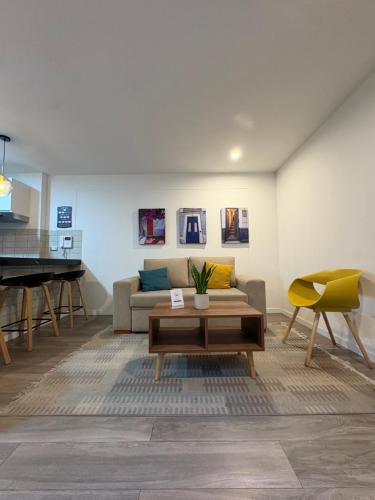 a living room with a couch and a table and a piano at Departamento 1BD con AC y terraza en el centro de Barranco in Lima