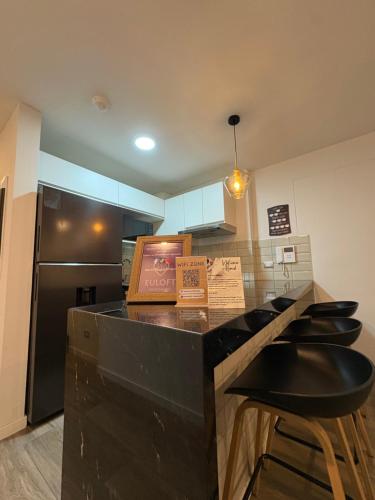 a kitchen with a counter with stools and a refrigerator at Departamento 1BD con AC y terraza en el centro de Barranco in Lima