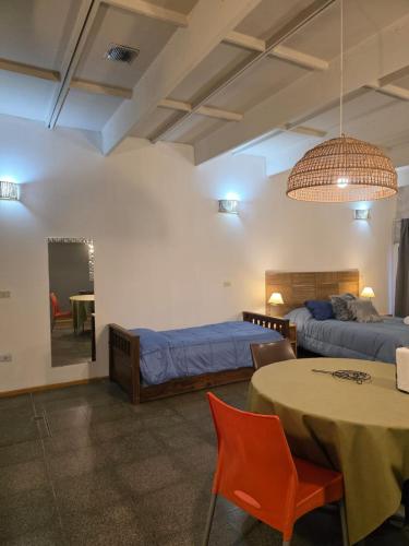 a room with two beds and a table and chairs at PALMARES DEL BOULEVARD - Aeropuerto Internacional Taravella - Campus Siglo 21 - Campus Blas Pascal - Sanatorio Allende - Estadio Kempes - Quorum - Mujer Urbana - Complejo Ferial Córdoba in Córdoba