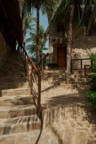 a set of stairs leading to a building with palm trees at Casa del Mar AC Rustic design Pool Paceful in Santa María Tonameca