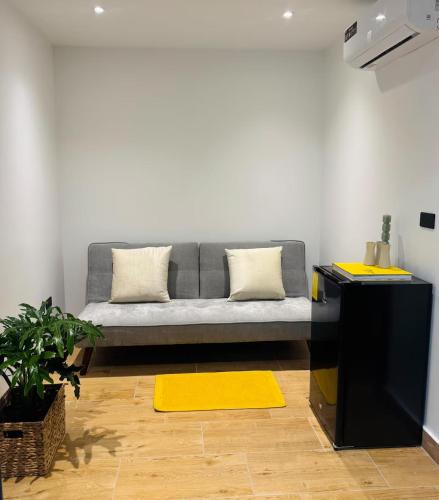 a living room with a gray couch and a yellow rug at Quinta Piedad Suites in Guayaquil