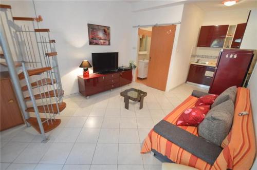 a living room with a bed and a kitchen at Apartment Nevena in Mali Lošinj