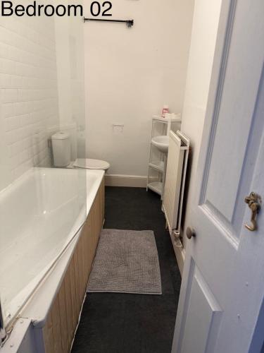 a bathroom with a tub and a toilet and a sink at 5 Brunswick St - Bedroom 02 downstairs in Bristol