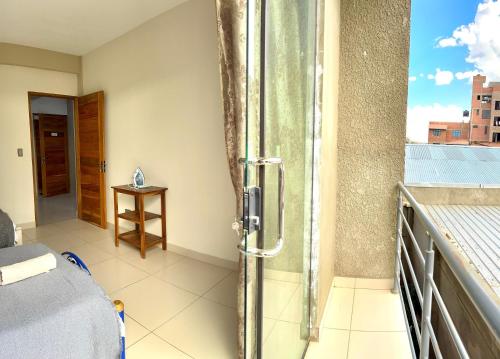 a balcony with a glass shower in a room at Alojamiento Bilbao in Quillacollo