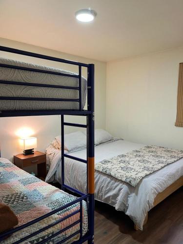 a bedroom with two bunk beds and a table with a lamp at Cabaña in Coihaique