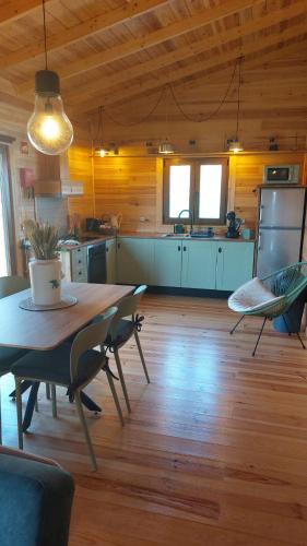 a kitchen with a table and chairs in a room at Casa de Cima - Sítio dos Henriques in Alfeizerão