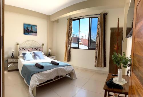 a bedroom with a bed and a large window at Alojamiento Bilbao in Quillacollo