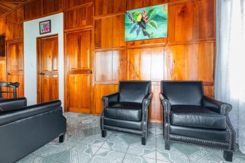 a room with two chairs and a painting on the wall at Departamento Ángeles del Arenal #1 in Fortuna