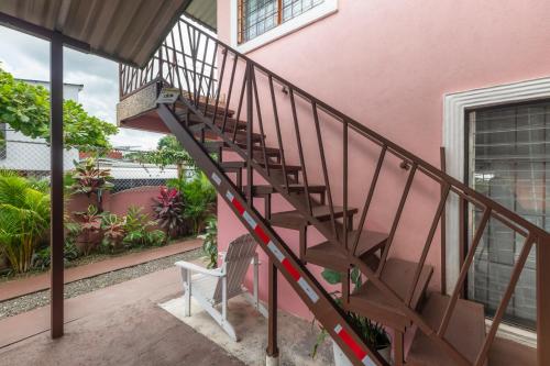 a staircase leading up to a pink house at Departamento Ángeles del Arenal #1 in Fortuna