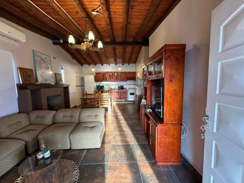 a living room with a couch and a kitchen at Refugio exclusivo entre Viñedos y Cordillera in Ciudad Lujan de Cuyo