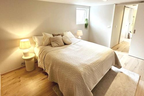 een slaapkamer met een groot bed en twee lampen bij Beautiful small apartment in the center of Reykjavík in Reykjavík