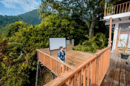 a man standing on the deck of a house at Cabaña de lujo en la montaña in Santa Marta