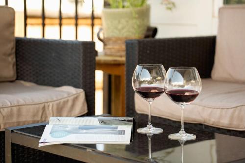 two glasses of red wine sitting on a table at Modern Austin Escape with Pool and BBQ in Austin