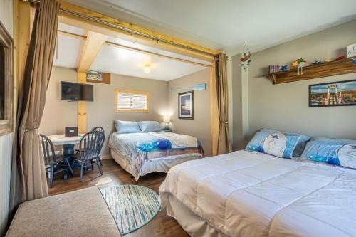 a bedroom with two beds and a desk and a table at Blue Water Bungalows in Milford