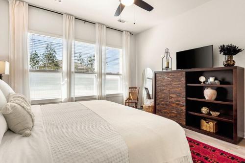 a bedroom with a bed and a flat screen tv at Modern Austin Escape with Pool and BBQ in Austin