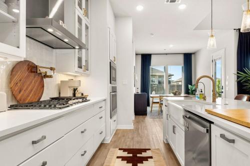 a kitchen with white cabinets and a counter top at Modern Austin Escape with Pool and BBQ in Austin