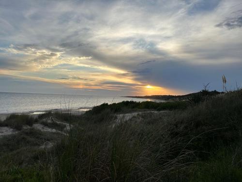 a sunset on a beach with the ocean in the background at Hermosa con vista al mar in Cuchilla Alta