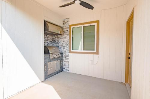 a small kitchen with a stove and a window at Plush & Roomy - Perfect for All Ages near KU & KC Duplex in Lawrence