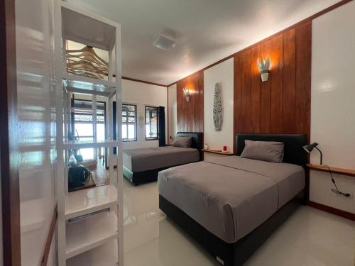 a bedroom with two beds and a book shelf at Pondok Asri in Mangsit