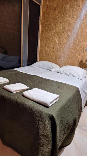 a bed with two white towels on top of it at Shop Sleep in Carnaxide