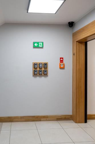 a room with a white wall with clocks on it at Apartamenty Przystanek Morska in Gdynia